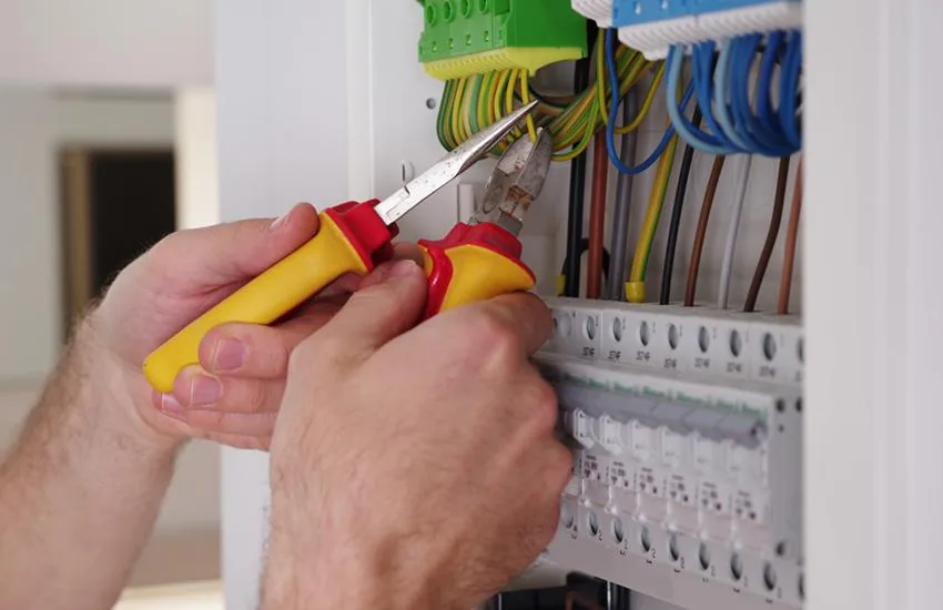 Hands working on an electrical panel