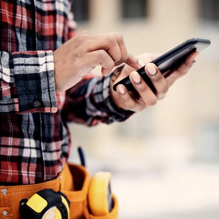 Tradesperson using an iPhone on site